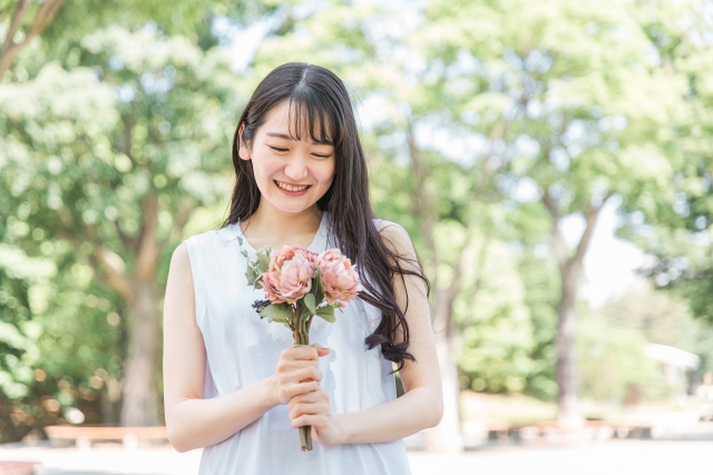 花束を持ちながら笑顔の女性